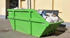 Green Skip On The Street Collecting Community Waste