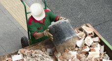 Man Placing Debris On A Skip Bin