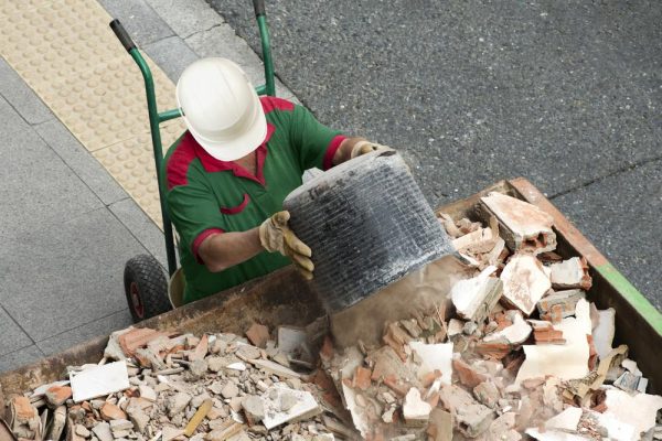 Man Placing Debris On A Skip Bin