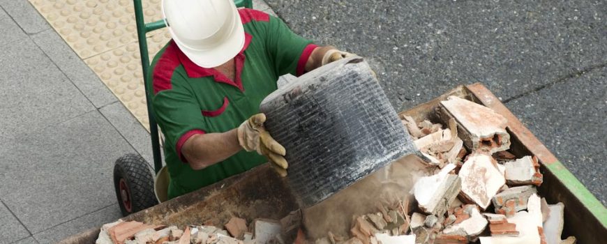 Man Placing Debris On A Skip Bin